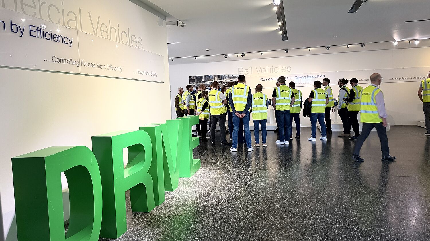 Werksführung bei Voith - Teilnehmer tragen Visitor Weste und schauen Richtung Sprecher.