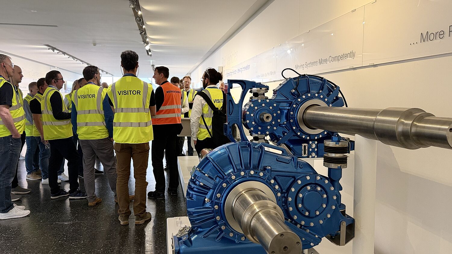 Werksführung bei Voith - Teilnehmer tragen Visitor Weste und schauen Richtung Sprecher.