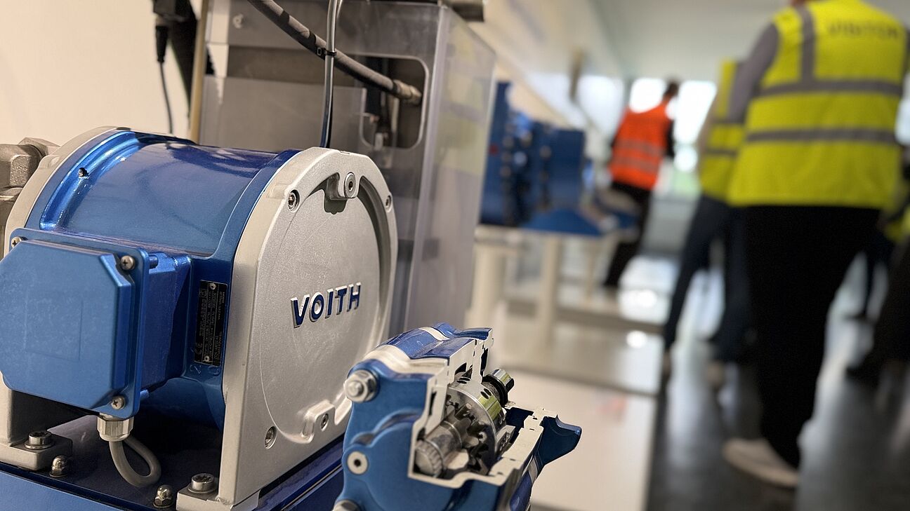Fachtagung Technische Sauberkeit 2026 - werksführung bei Voith. Teilnehmer werden von hinten Richtung Sprecher fotografiert und tragen Visitor Westen in gelb