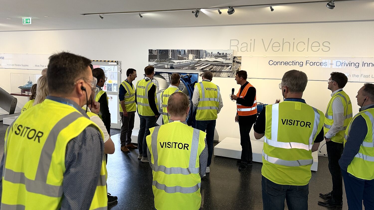 Werksführung bei Voith - Teilnehmer tragen Visitor Weste und schauen Richtung Sprecher.